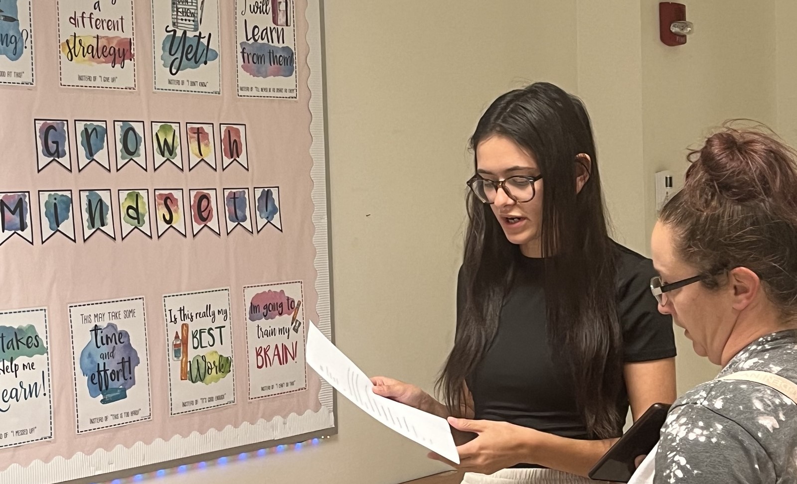 A teacher showing a parent a lesson plan.