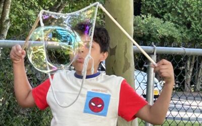 A child blowing a massive soap bubble