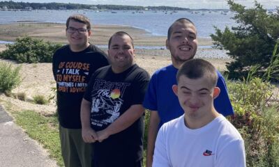 A group of young men on a bike path near the beach.